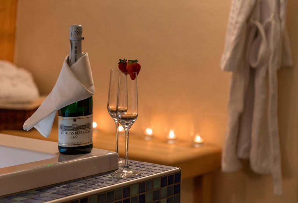 Sparkling wine with two champagne glasses on the edge of a bathtub in the wellness area of the hotel in Karlstadt