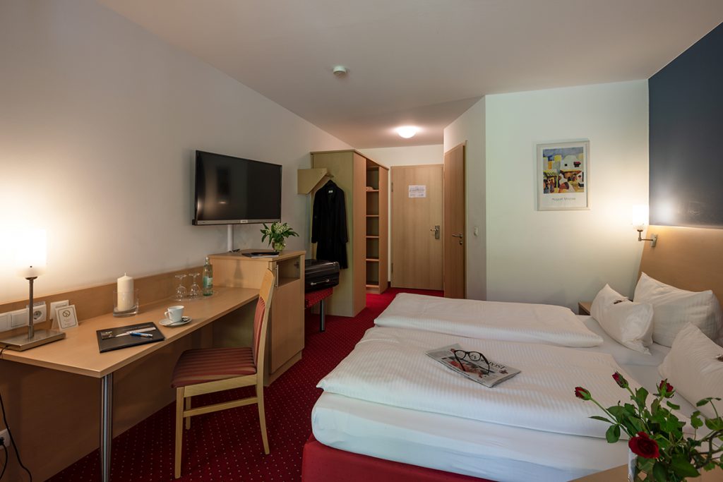 Gemütlich eingerichtetes Zimmer im Hotel in Karlstadt mit Doppelbett, Flachbildschirm und Schreibtisch