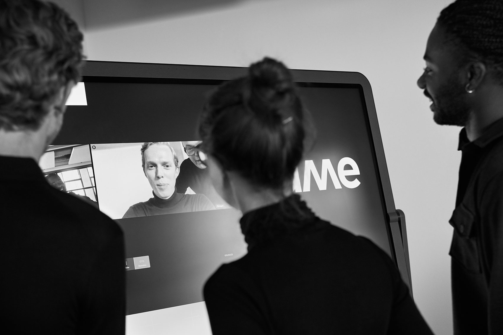 Teilnehmer an einem Seminar schauen auf eine Leinwand während einer Videokonferenz im Tagungshotel Mainfranken